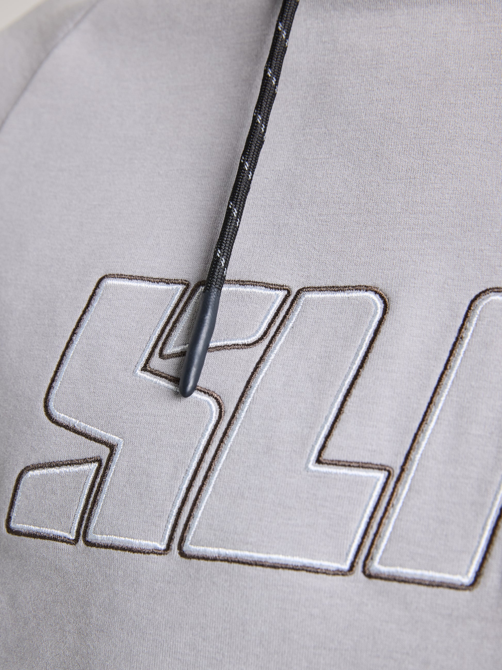 Close-up of the LOGO HOODIE by SLAM—a men's warm sweatshirt with an adjustable hood, showcasing a gray design and black drawstring. Large embroidered "SLD" letters are prominently displayed in white with a black outline, accompanied by the iconic Slam logo on the fabric.